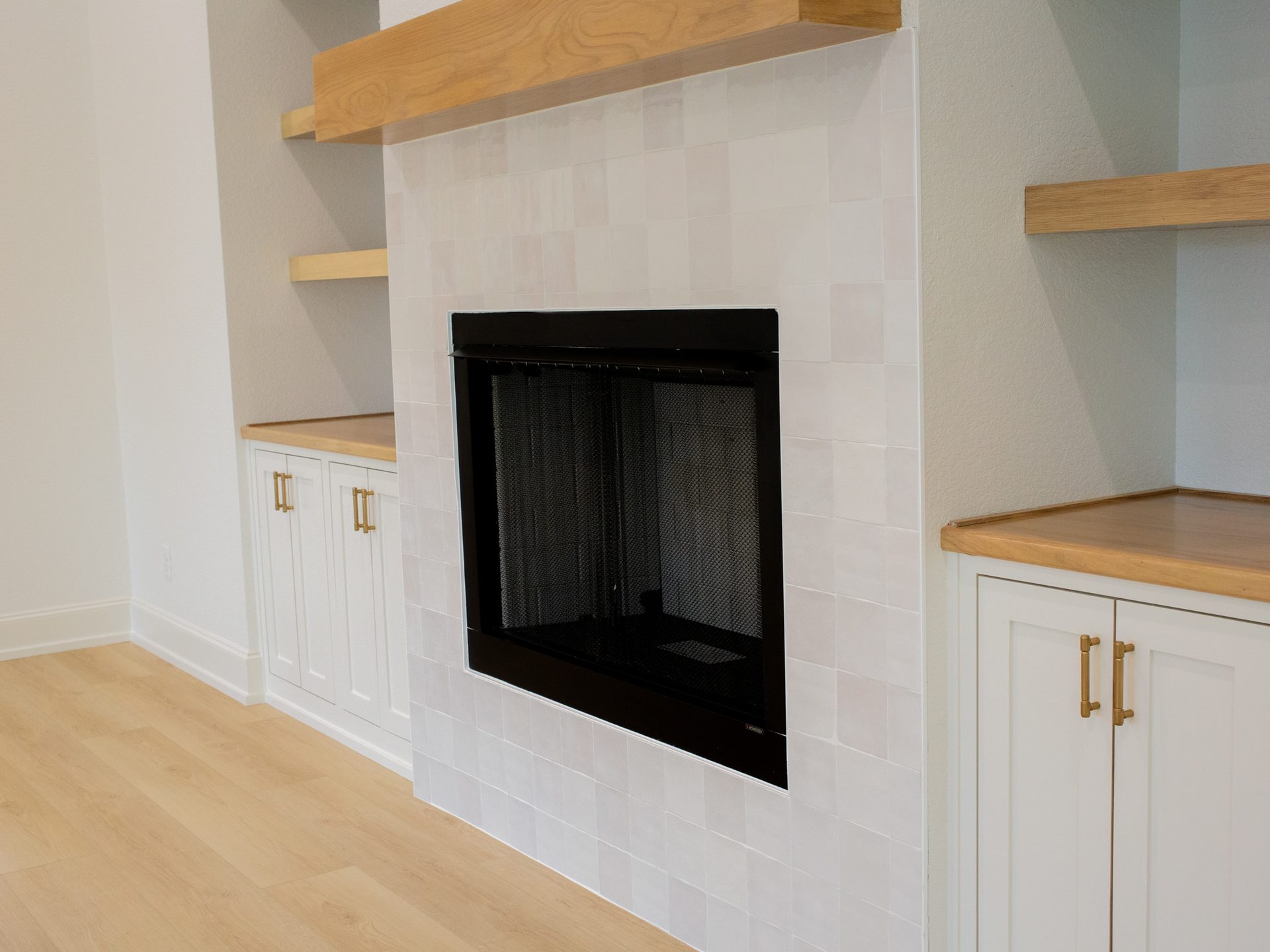 Living room with stone fireplace and built-in bookshelves.