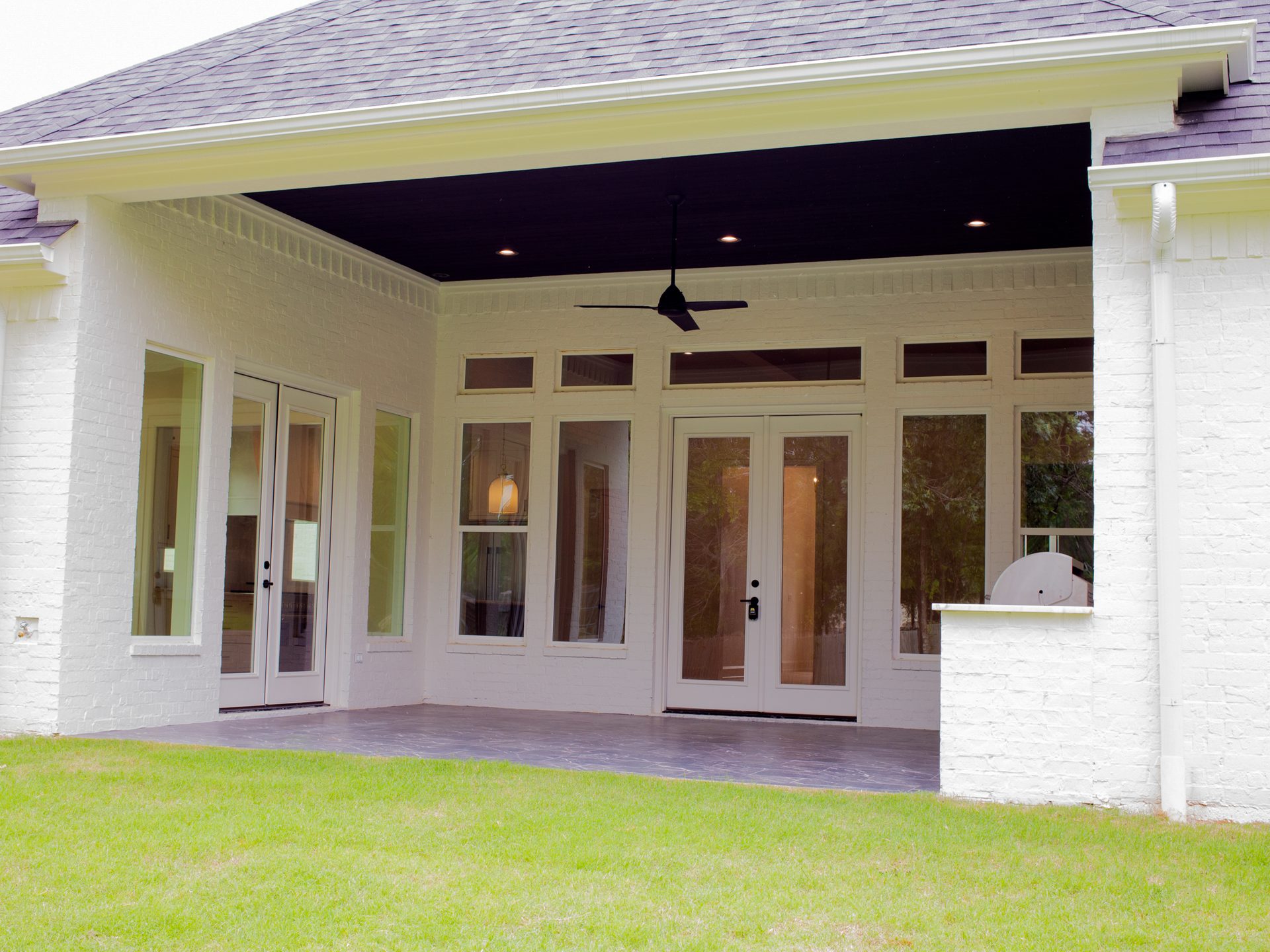 Back patio with covered outdoor living area and landscaped yard.