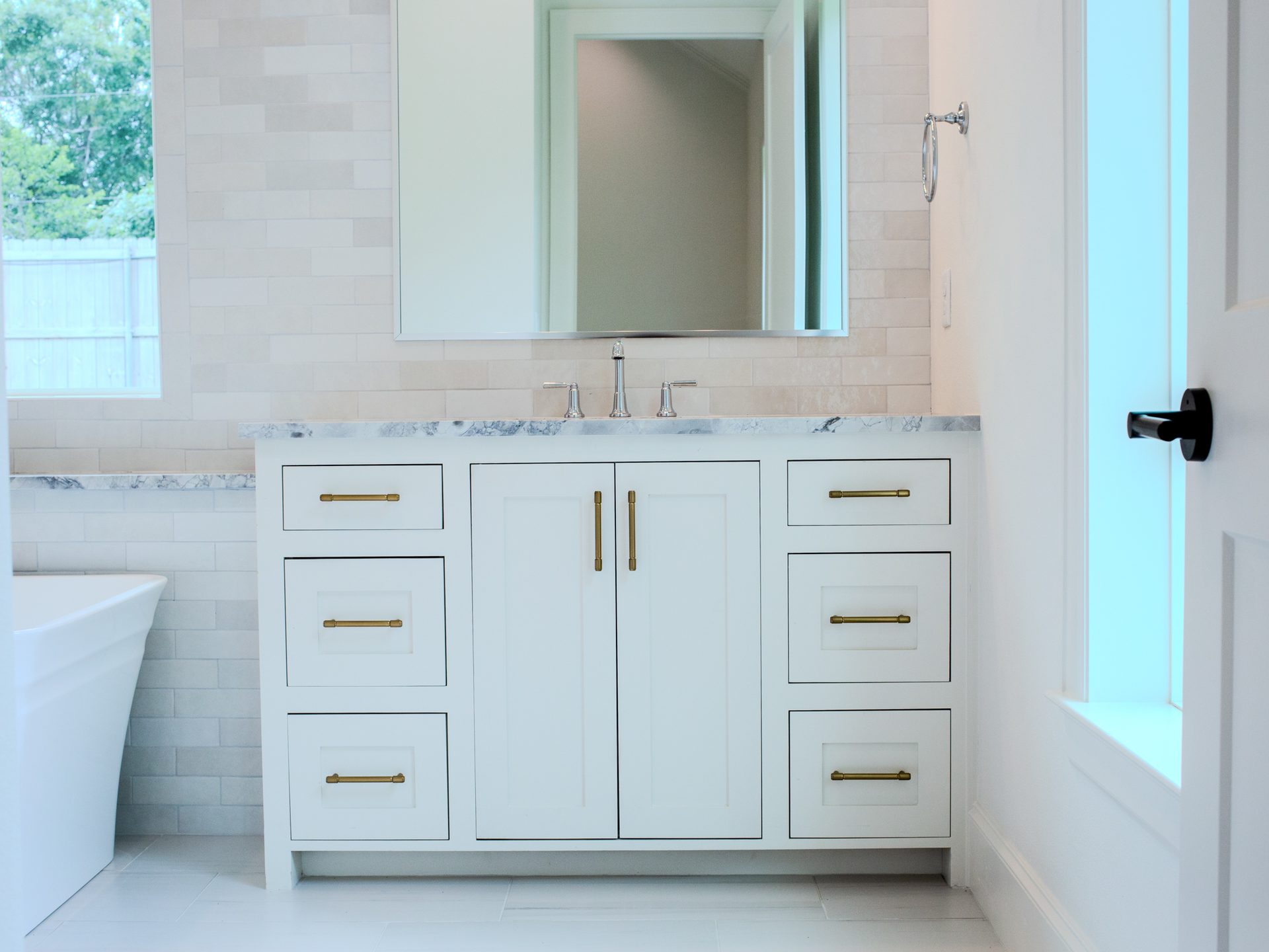 Vanity with marble counter, brass hardware, and chrome faucet.
